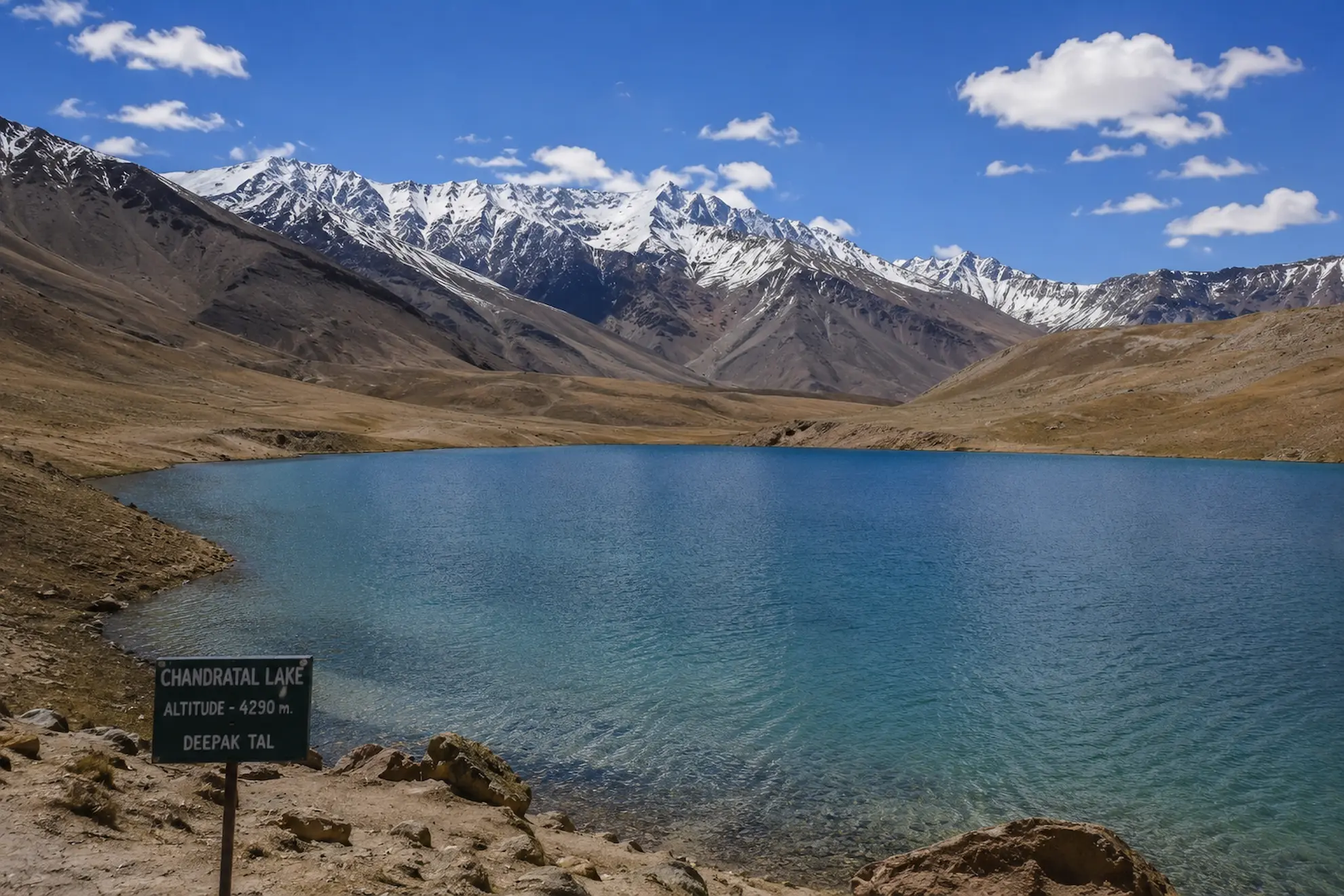 Chandratal crescent lake reflecting snow-capped peaks in Himachal Pradesh