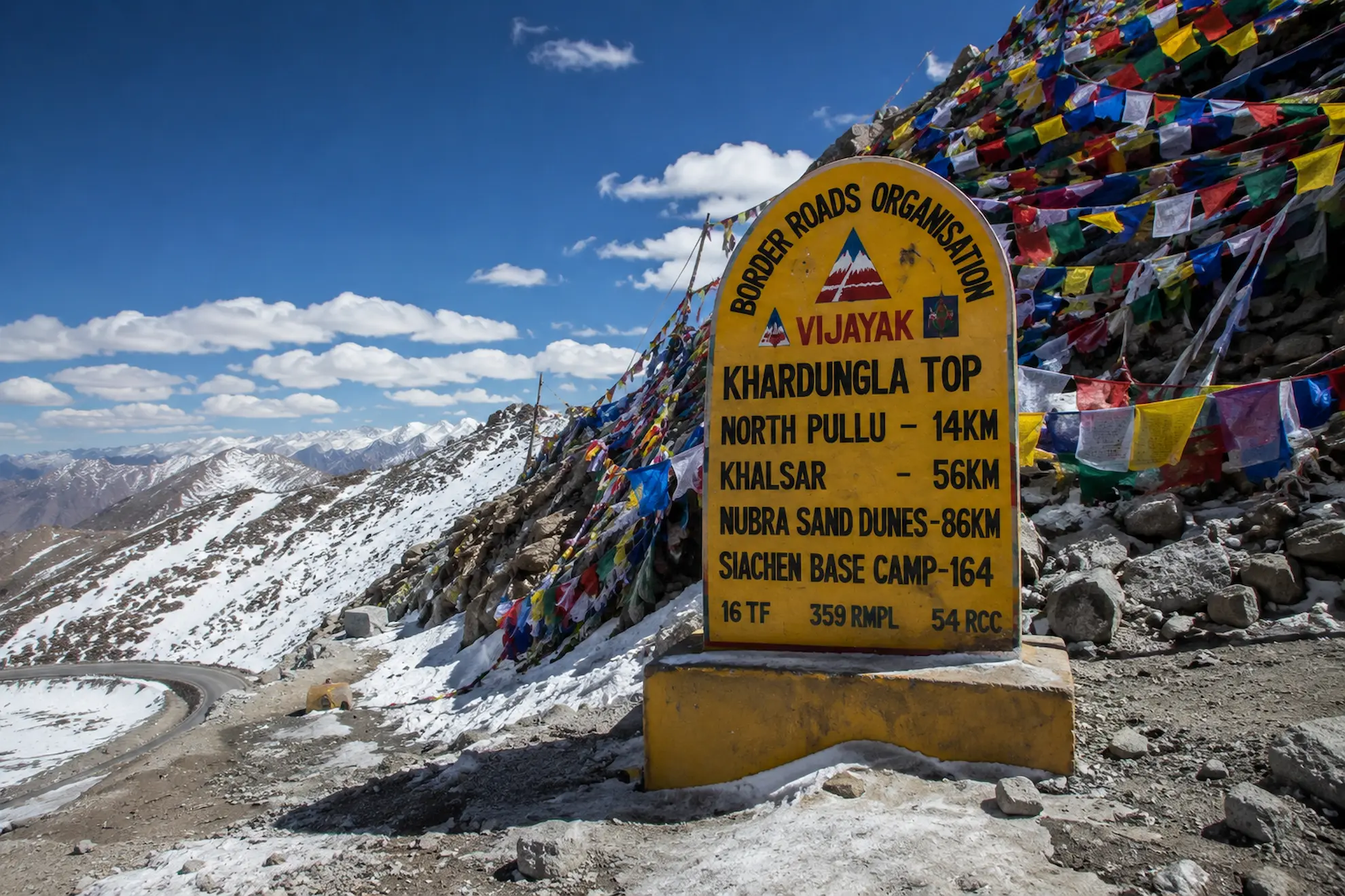 Road winding through snow at Khardung La, one of the world's highest motorable passes