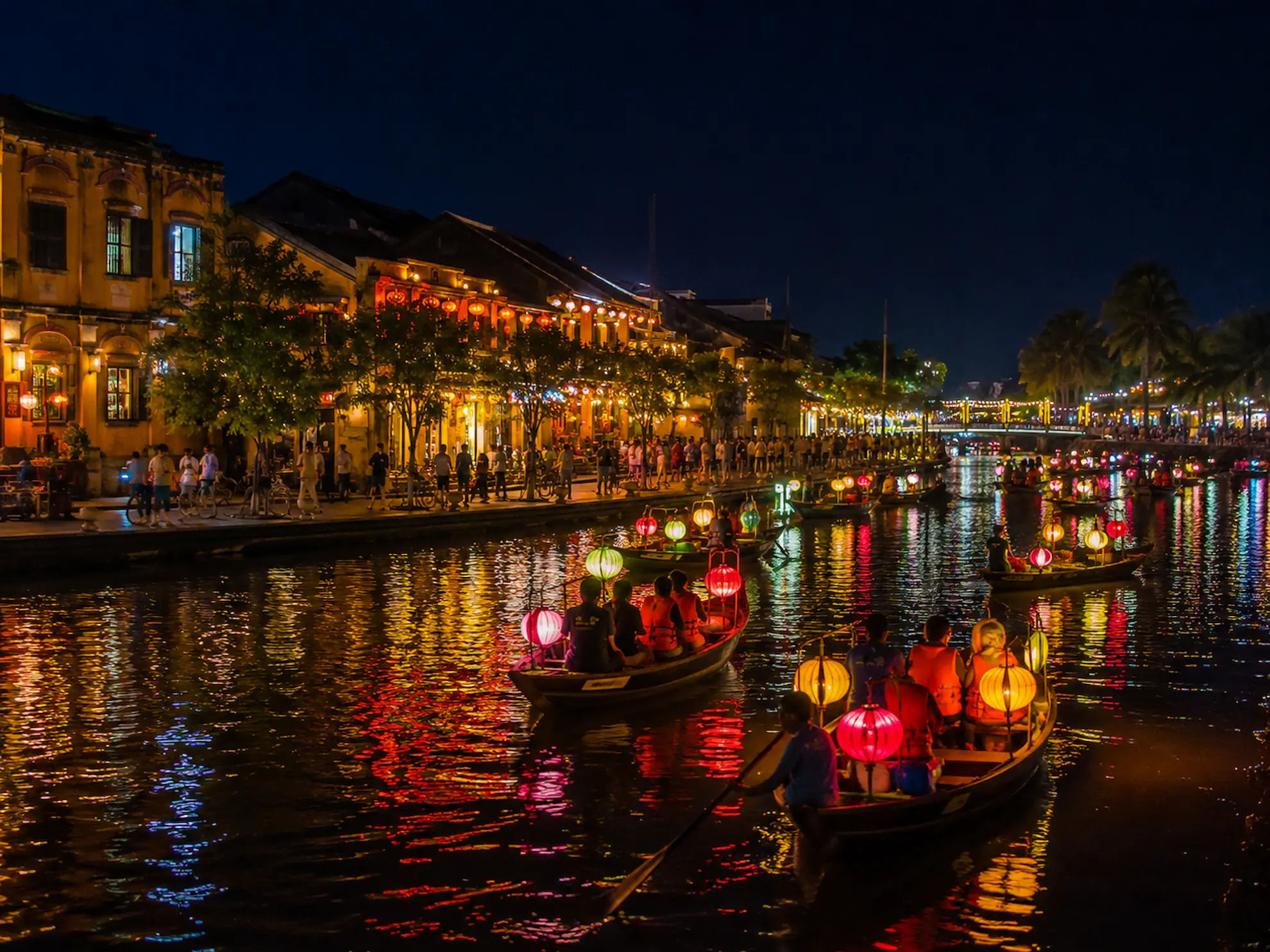Colourful silk lanterns floating above the river in Hoi An on a full moon night