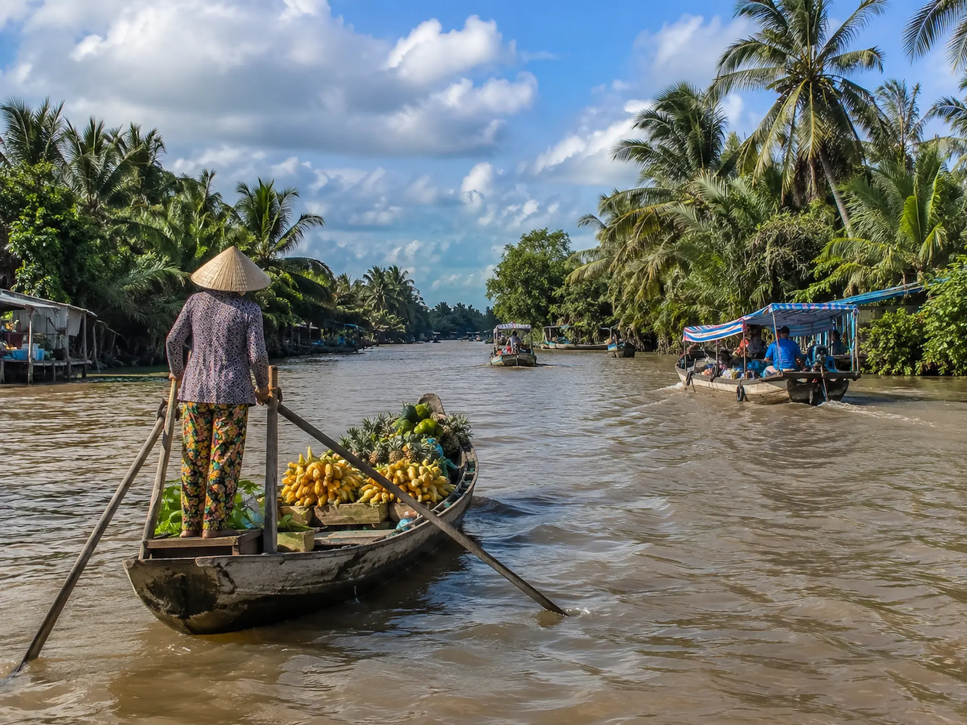 Narrow wooden boat navigating a narrow canal through the Mekong Delta, Vietnam